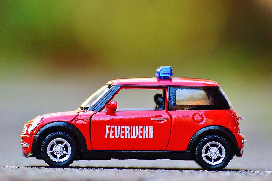 Rotes Feuerwehrauto Spielzeugauto vor grünem Hintergrund